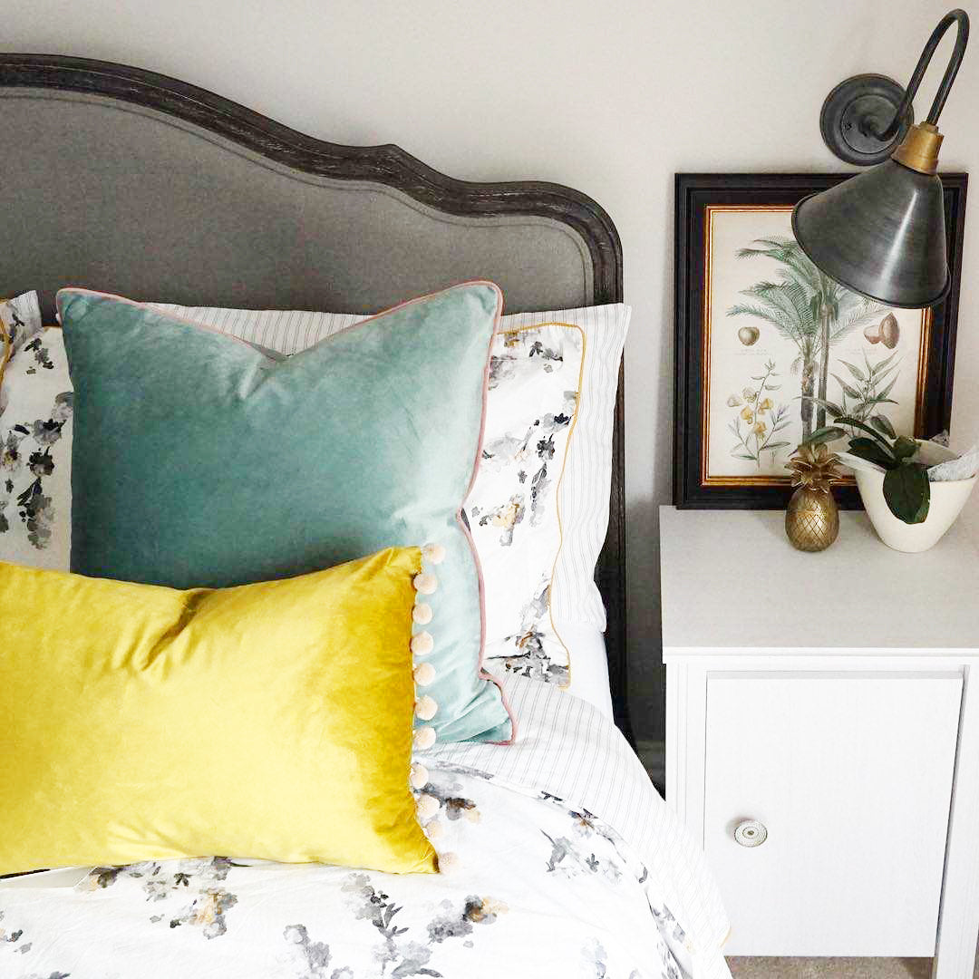 Industrial lights in a bedroom with velvet cushions