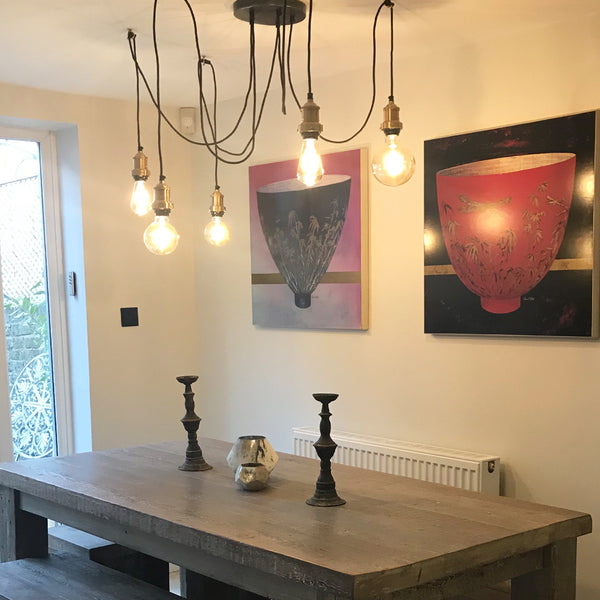 5 wire modern chandelier with exposed bulbs in a dining room 