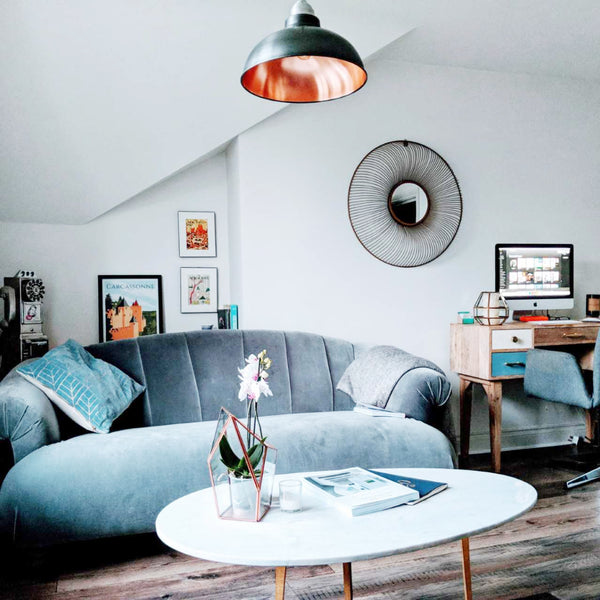 Light blue velvet sofa in a living room interior with vintage lights