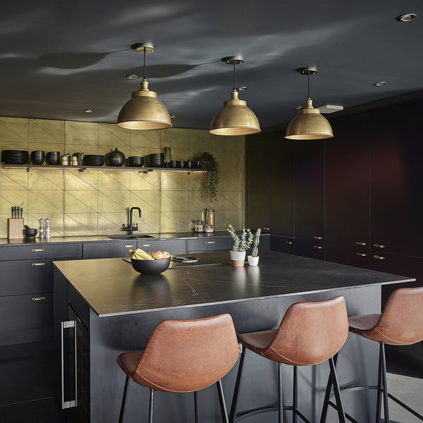 Barn conversion kitchen interior with dark concrete and brass accents