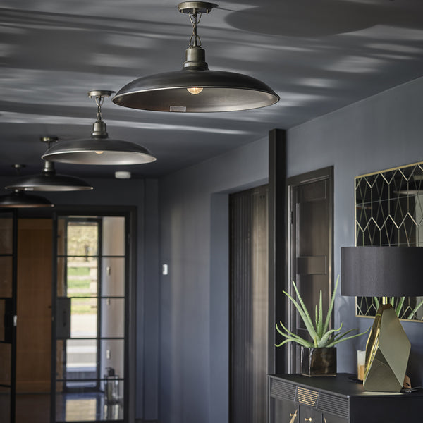 Open plan kitchen with dark concrete walls and pewter lights