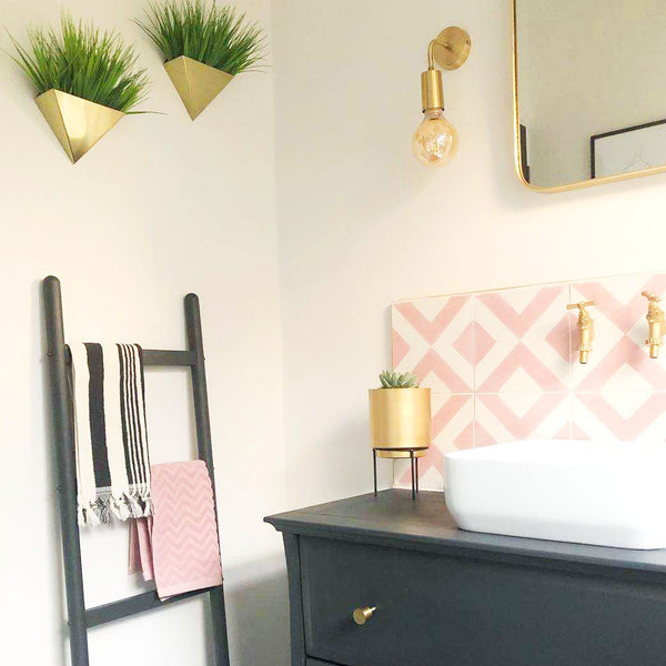 Pastel pink bathroom interior design with brass lights