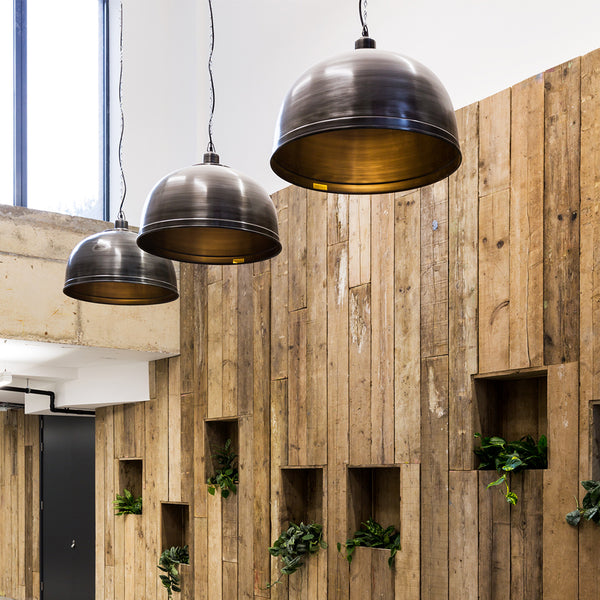 Trio of oversized industrial pendants in a commercial interior 