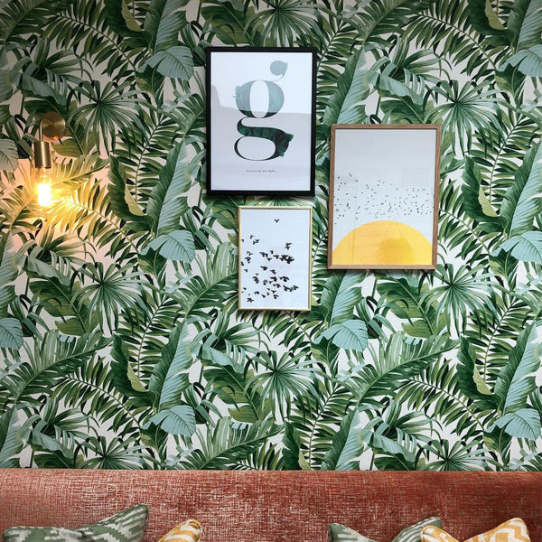 Botanical print wallpaper and vintage lights in a dining room