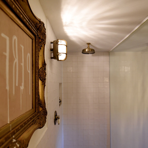 Bathroom interior with brass bulkhead light