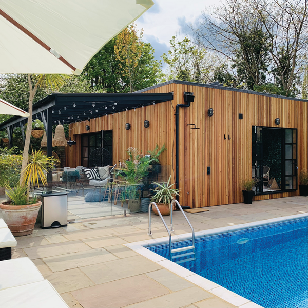 A modern outdoor living space with pool and industrial lighting