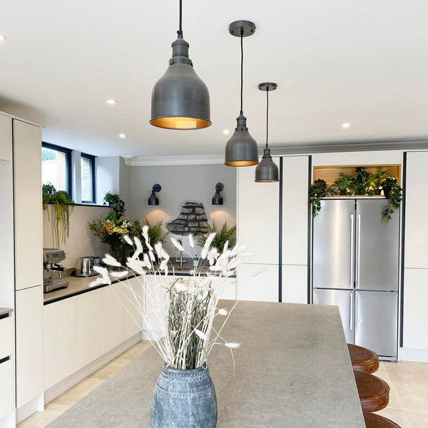 A modern kitchen with pewter pendant lighting