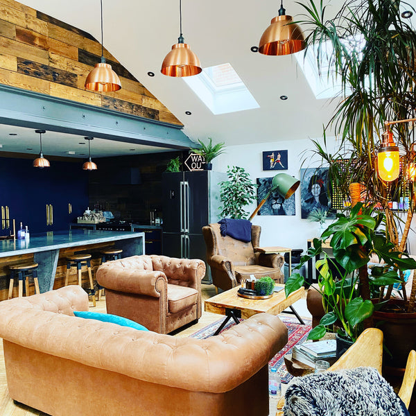 Leather sofas and pendant lights in an open living room