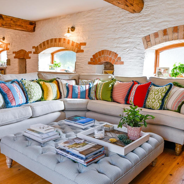 A white sofa with numerous coloured cushions