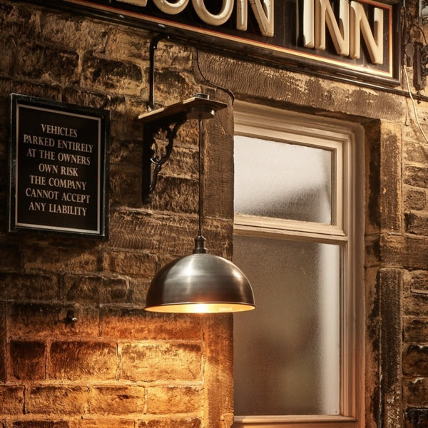 An outdoor light hanging outside a pub at night