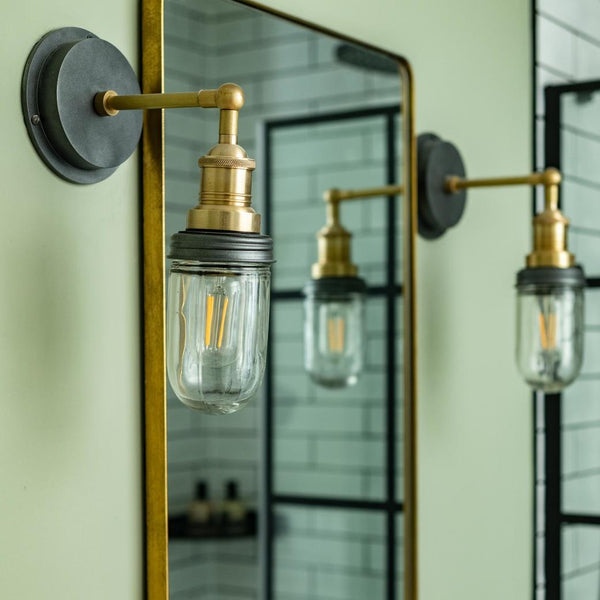 Vintage-style brass bathroom wall lights on either side of a mirror