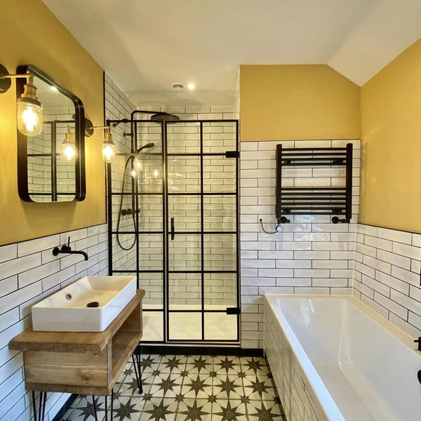 A bright bathroom with yellow walls and patterned tiles