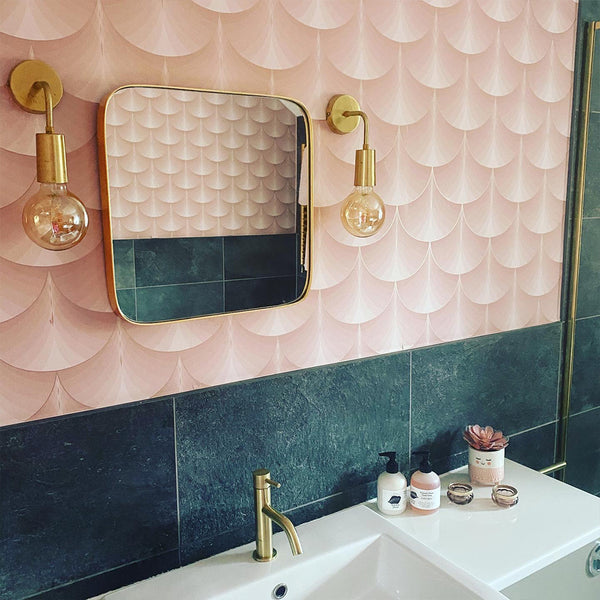Pink scallop bathroom interior with brass wall light