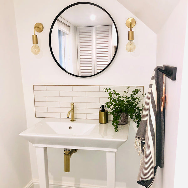 All white bathroom with circular mirror