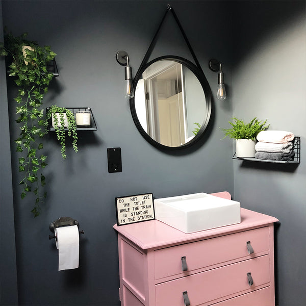 Bathroom with circular mirror and wall lights