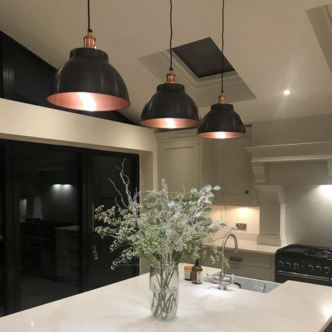 A modern kitchen with marble worktop and metal pendant lights by Industville
