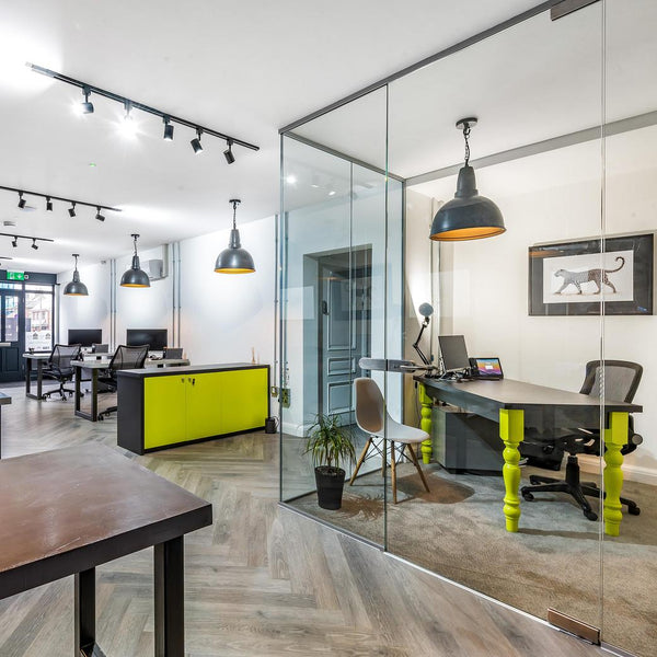 A modern office interior with bright furnishings and hanging industrial lights