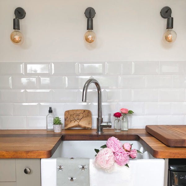 Three wall lights above a kitchen sink 