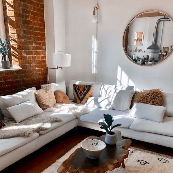 A white living room with faux fur throws and cushions