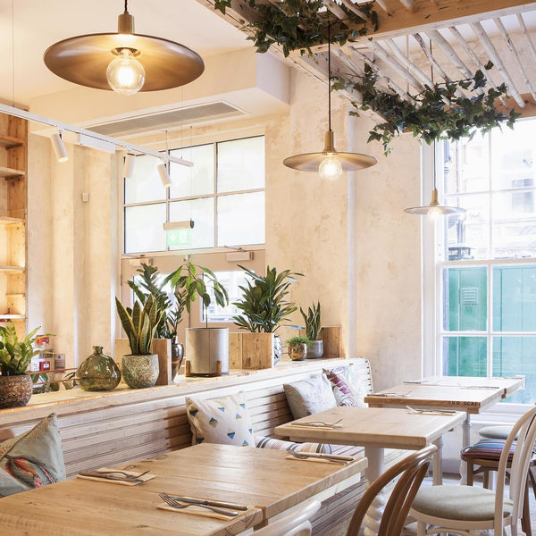 Flat pendant lights hanging over a dining area in a hotel restaurant 