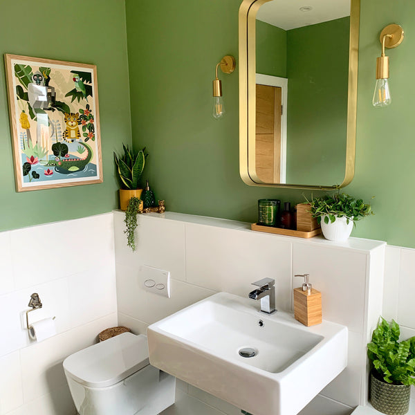 An art deco bathroom with brass furniture and green walls