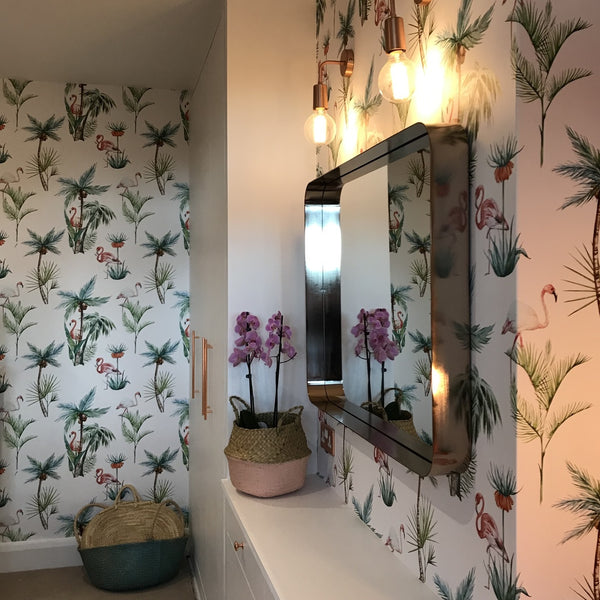 Tropical wallpaper paired with a square mirror and retro lights