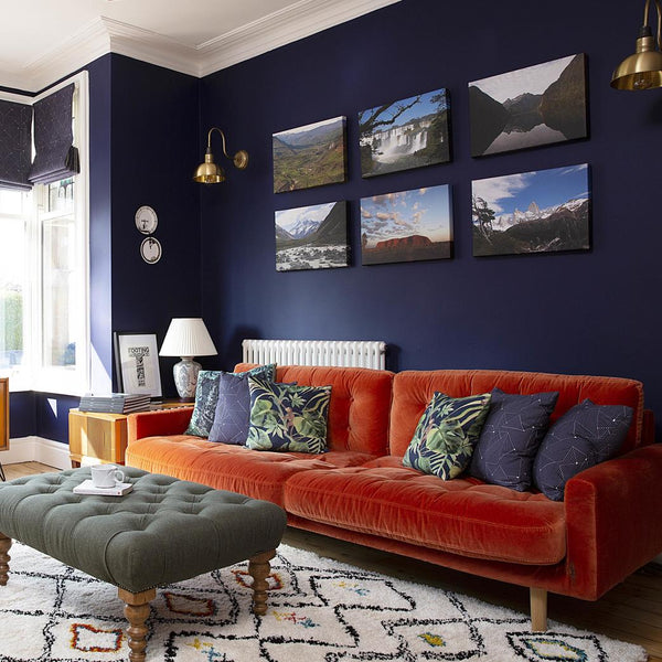 A luxury living room with dark walls and brass lighting