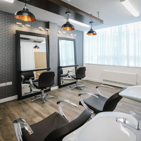 A minimalist salon interior with industrial lights by Industville