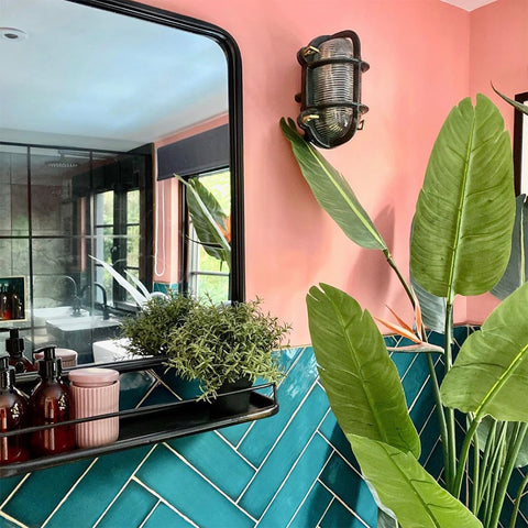 A pink and blue bathroom with antique-style mirror 