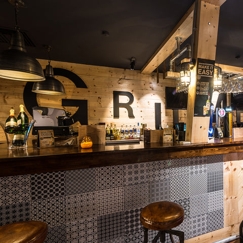 A wooden bar interior with colourful lighting and exposed beams