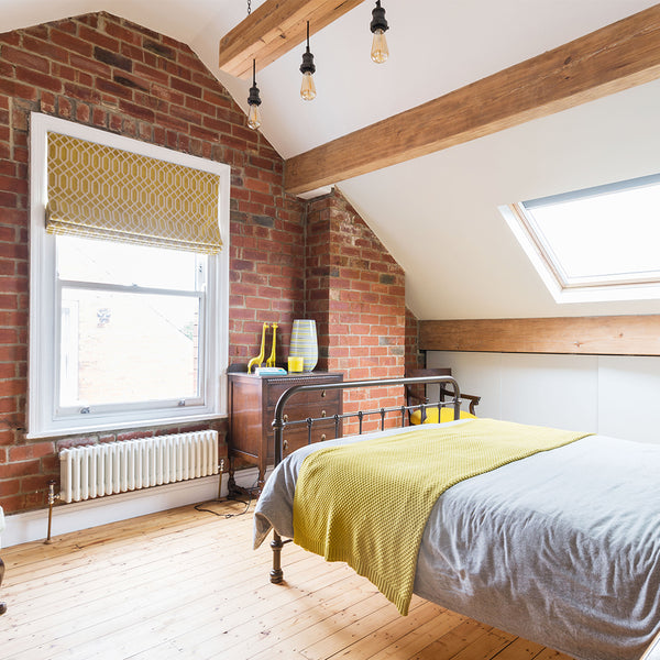 A loft conversion bedroom with exposed brick walls