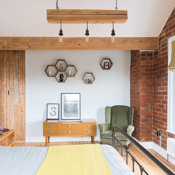 A bedroom with exposed brick walls and wooden beams