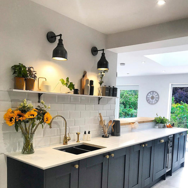 A modern kitchen with black cupboards and industrial lighting