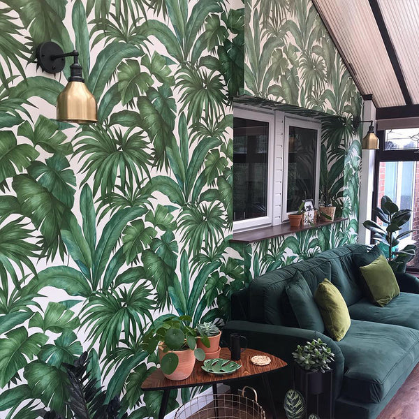 A green living room interior with floral wallpaper