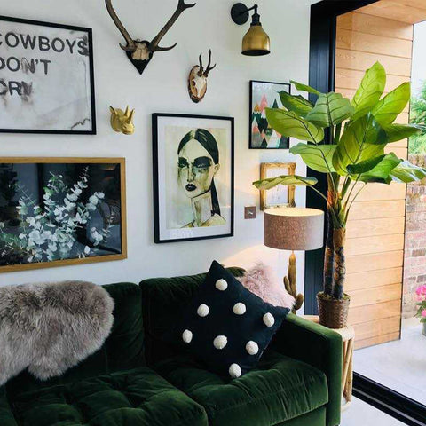 A green living room interior with plants and wall art
