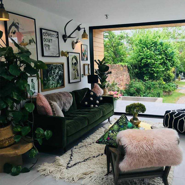 A green living room with plants and metal lighting