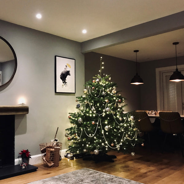 Large Christmas tree with lights and decorations in living room