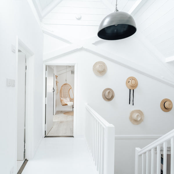A white, open hallway with metal industrial light