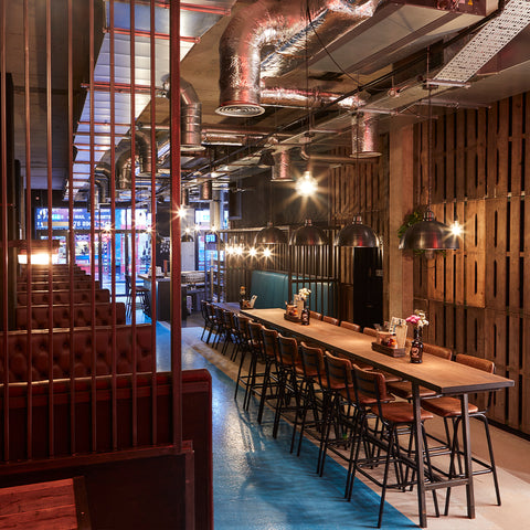 A wooden restaurant interior with seating and industrial lights