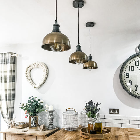 Hanging industrial lights by Industville over a wooden kitchen worktop