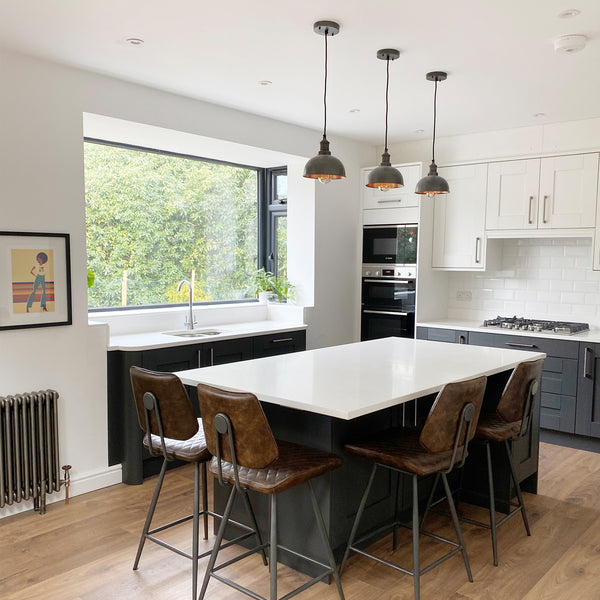 A modern kitchen with leather stools