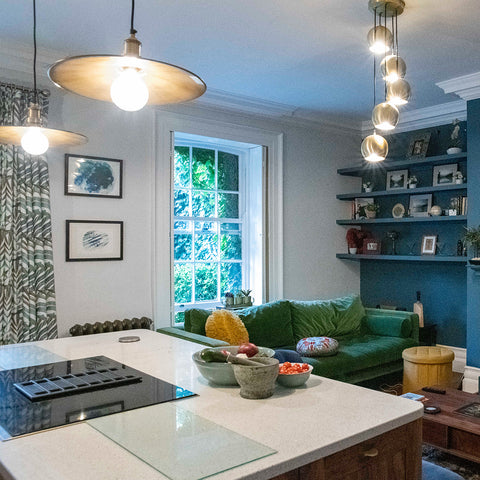 An open plan kitchen and living space with different style lighting