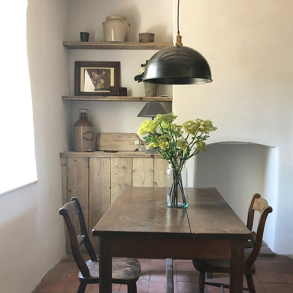 A rustic dining room with wooden table and industrial light by Industville