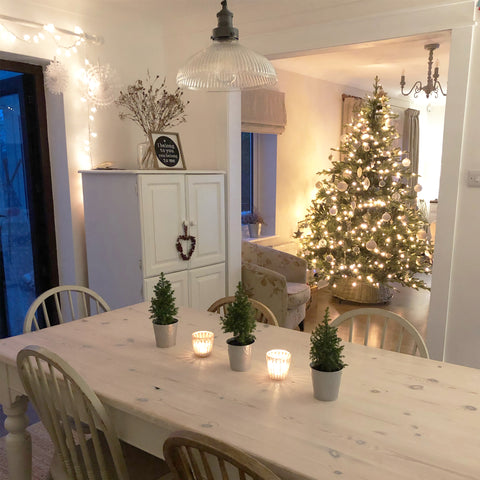 A pale home interior with Christmas lights and tree