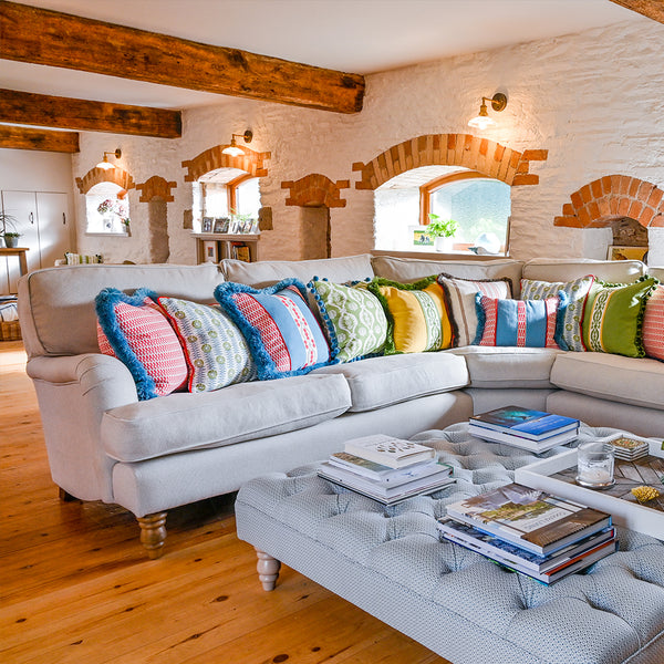 A rustic living room with patterned cushions and metal lighting