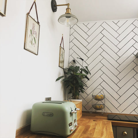 A small kitchen with patterned wallpaper and metal wall light by Industville