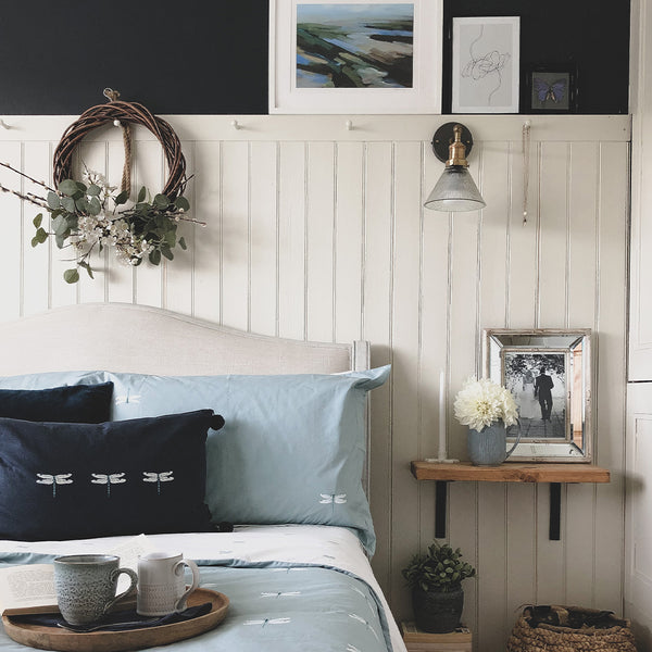 A blue monochrome traditional bedroom with wooden features