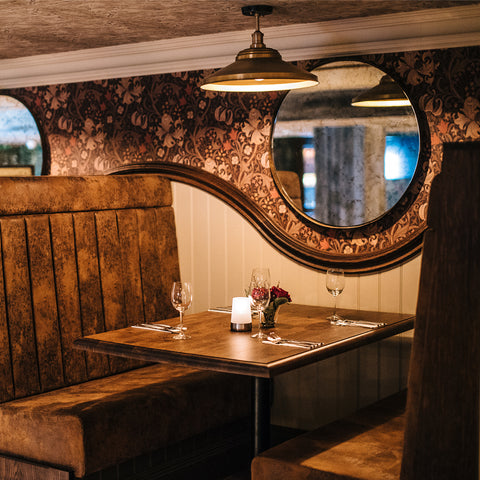 A wooden restaurant interior with industrial hanging lights by Industville