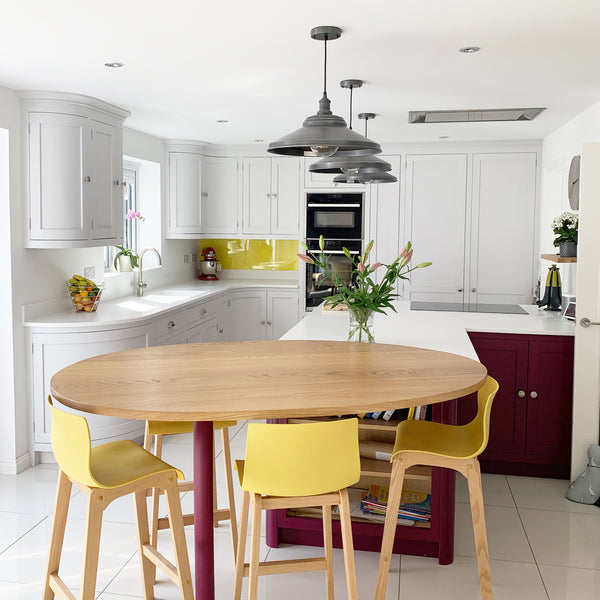 A white kitchen with yellow chairs