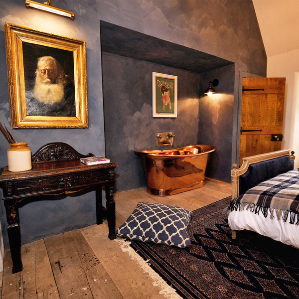 A warm bedroom interior with coloured wall and copper fixtures